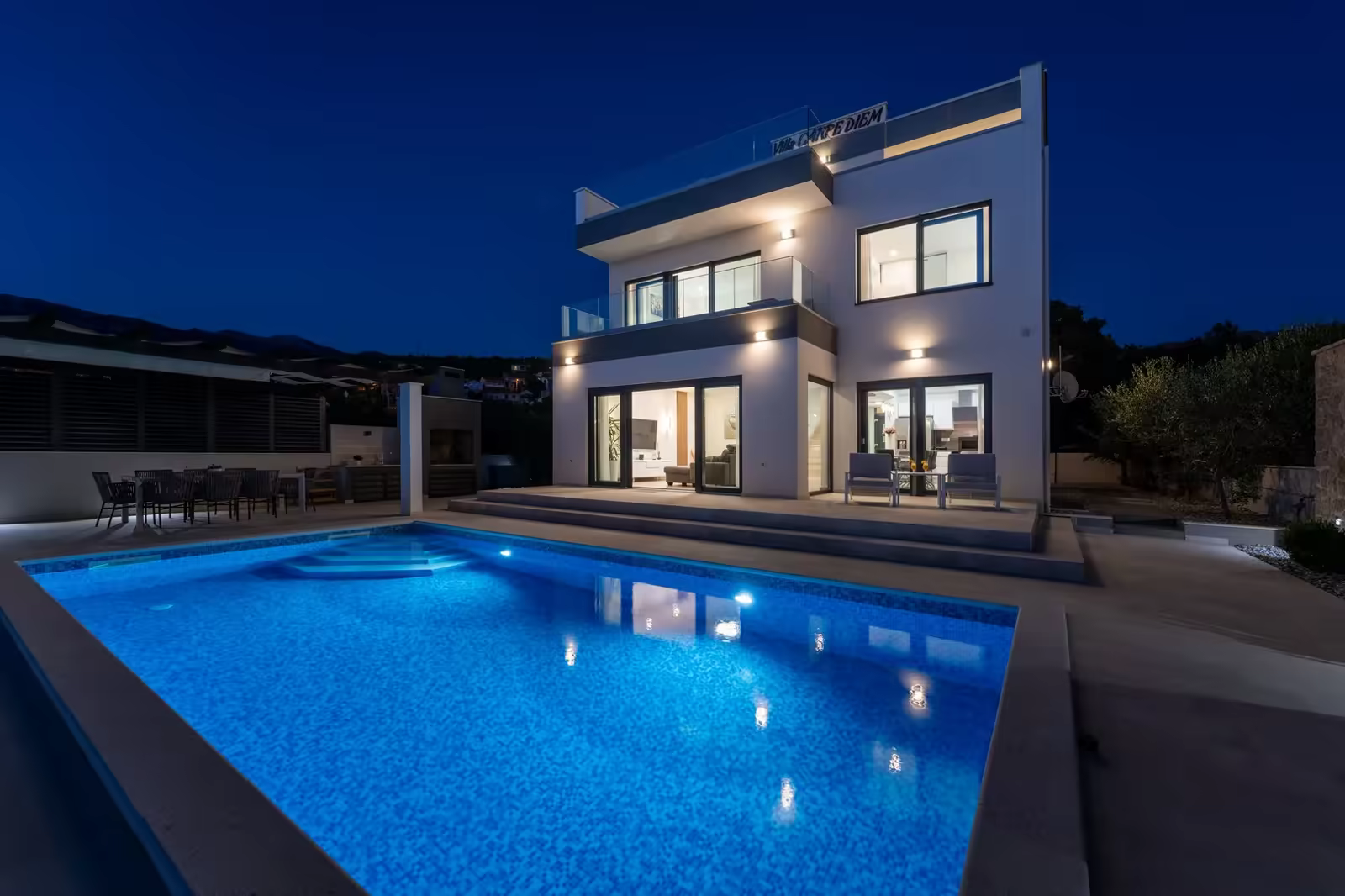 Contemporary villa terrace and pool at dusk